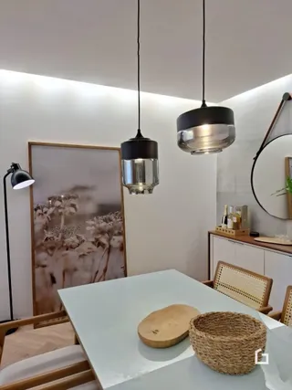 Imagem de um ambiente interno com mesa e iluminação pendente.