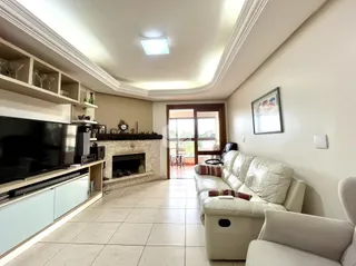 Sala de estar com lareira e sofá de cor clara.