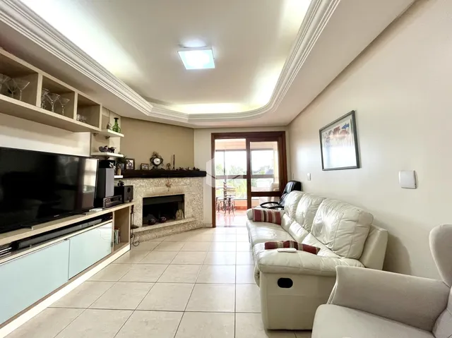Sala de estar com lareira e sofá de cor clara.