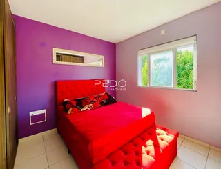 Quarto com cama vermelha e paredes roxas.