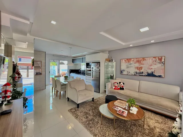 Sala de estar moderna com cozinha integrada e piso de cerâmica.