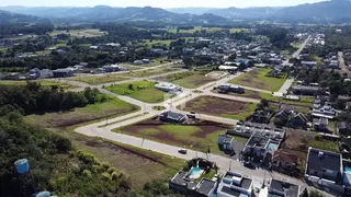 Vista aérea de uma área residencial com campos e vegetação no Brasil.