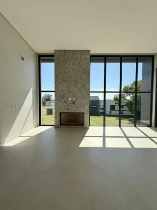 Ambiente interno com pilastra de pedra e grandes janelas de vidro.