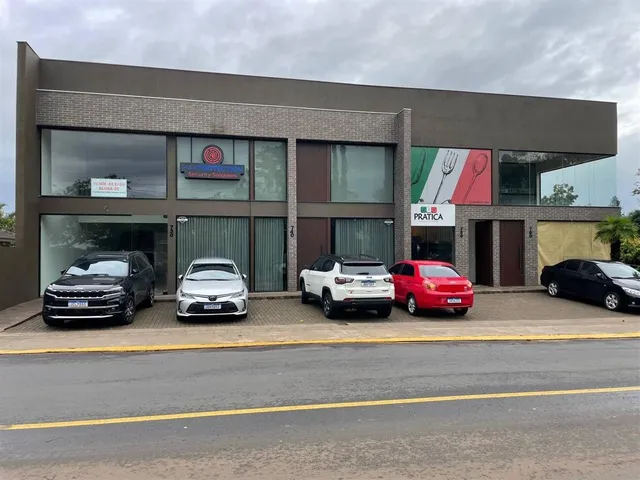 Fachada de um prédio comercial em Lajeado, Brasil, com estacionamento na frente.