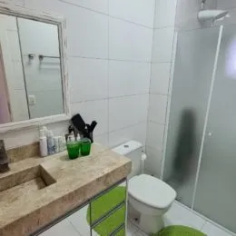 Banheiro com bancada de pedra e espelho em um imóvel.