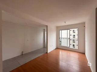 Vista de um corredor interno com piso de madeira e cerâmica.