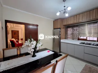Foto de uma cozinha com armários de madeira e bancada escura em um imóvel.