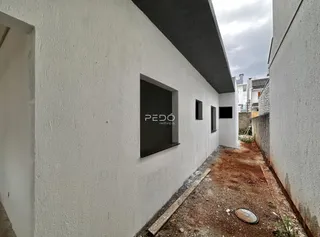 Fachada de um imóvel em Lajeado, Brasil, mostrando uma parede branca e um pátio estreito.