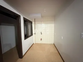 Corredor interno com piso de cerâmica e paredes claras.