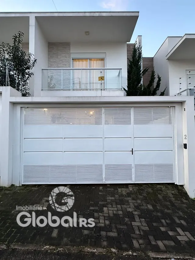 Fachada de uma casa branca com garagem.