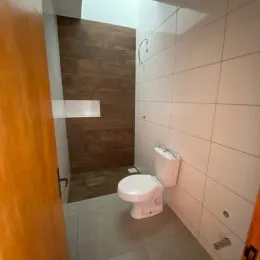 Banheiro com revestimento de azulejos brancos.