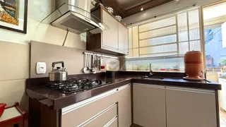 Cozinha com armários de madeira escura e bancada.