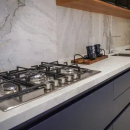 Vista de um balcão de cozinha com cooktop e bancada branca.