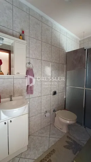 Foto de um banheiro com revestimento de cerâmica clara.