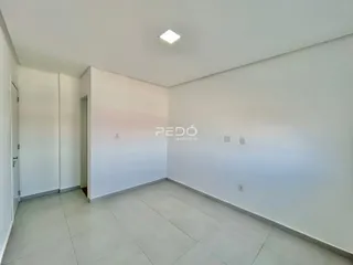 Interior de uma sala com paredes brancas e piso de cerâmica.