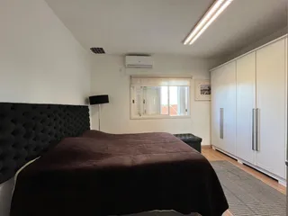 Quarto com cama grande e armário embutido branco.