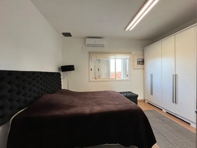 Quarto com cama grande e armário embutido branco.