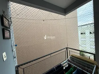 Vista de um corredor interno com parede texturizada e grade de segurança.