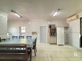 Foto de uma sala de jantar com mesa e cozinha em um imóvel no Brasil.