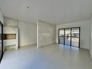 Sala de estar ampla com piso claro e paredes brancas em um imóvel.