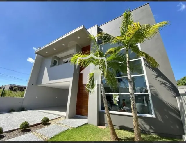 Fachada moderna de uma residência em Lajeado, Brasil, com paisagismo frontal.