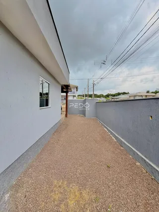 Exterior de duas edificações separadas por um caminho de cascalho.