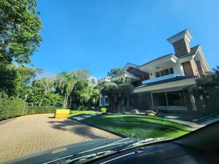 Fachada de uma residência em Lajeado, Brasil, com jardim e paisagismo.