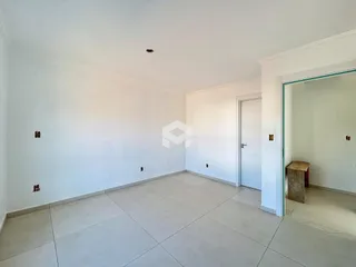 Sala ampla com piso de cerâmica e paredes brancas.