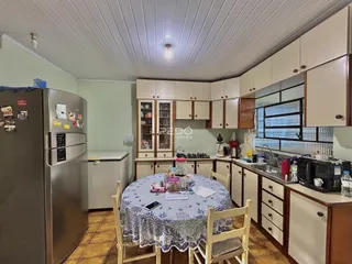 Foto de uma cozinha com armários e mesa de jantar em um imóvel no Brasil.