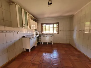 Imagem de uma cozinha com revestimento cerâmico e piso de terracota.