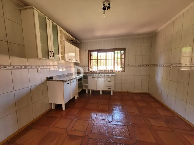 Imagem de uma cozinha com revestimento cerâmico e piso de terracota.