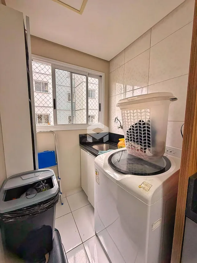 Interior de uma cozinha com janela e revestimento cerâmico.