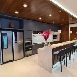 Cozinha moderna com armários escuros e ilha central.