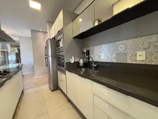 Cozinha moderna com armários brancos e bancadas escuras.