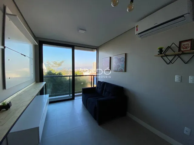 Sala de estar com porta de vidro e vista para a paisagem.