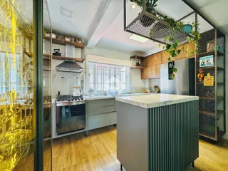 Cozinha moderna com ilha e piso de madeira clara.