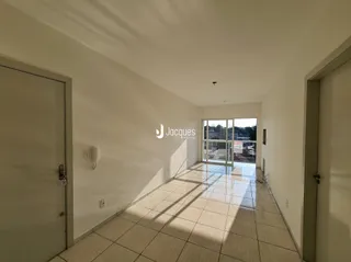 Corredor interno de uma residência com piso de cerâmica clara.