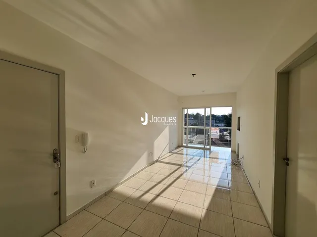 Corredor interno de uma residência com piso de cerâmica clara.