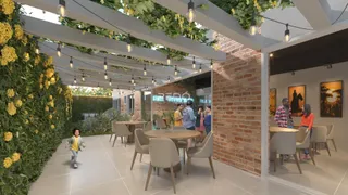 Área externa coberta com decoração vegetal e mesas de jantar.