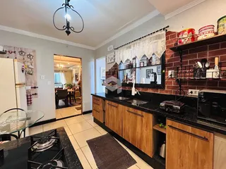 Vista da cozinha de uma propriedade em Lajeado, Brasil, com armários de madeira e bancadas escuras.