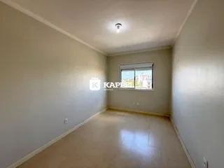 Foto de um corredor com piso de madeira clara e paredes brancas.