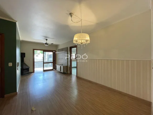 Sala de estar com piso de madeira e porta de vidro.
