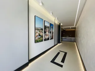 Corredor interno de um imóvel moderno com paredes brancas e iluminação embutida.