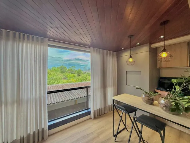 Sala de estar com vista para a paisagem externa através de uma janela ampla.