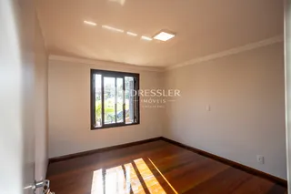 Sala de estar com piso de madeira e janela.