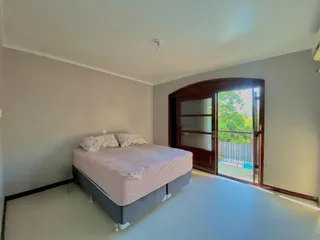 Quarto com cama e porta de madeira.