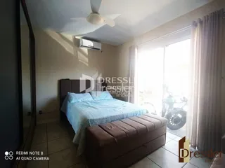 Quarto com cama e cortinas em uma residência.