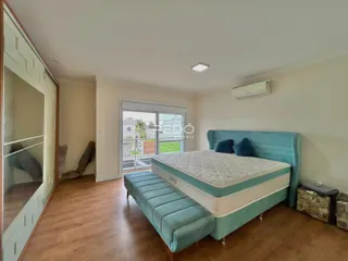 Quarto com cama azul e piso de madeira em imóvel no Lajeado.
