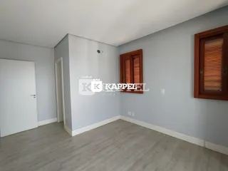 Ambiente interno com paredes cinzas e piso de madeira clara.
