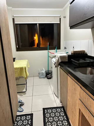 Foto interna de uma cozinha com armários de madeira e piso de cerâmica.
